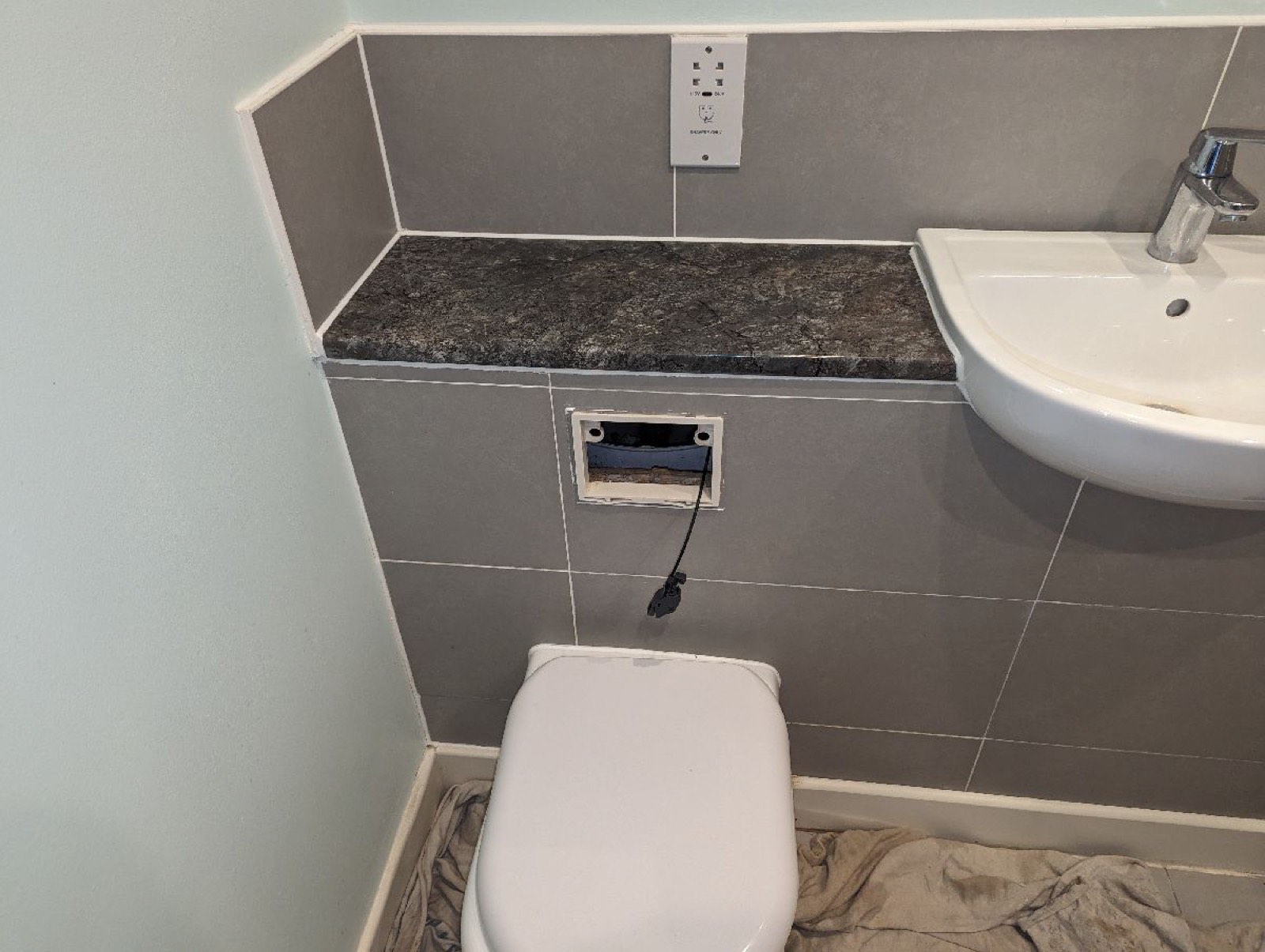 Finished bathroom basin with tiled shelf detail