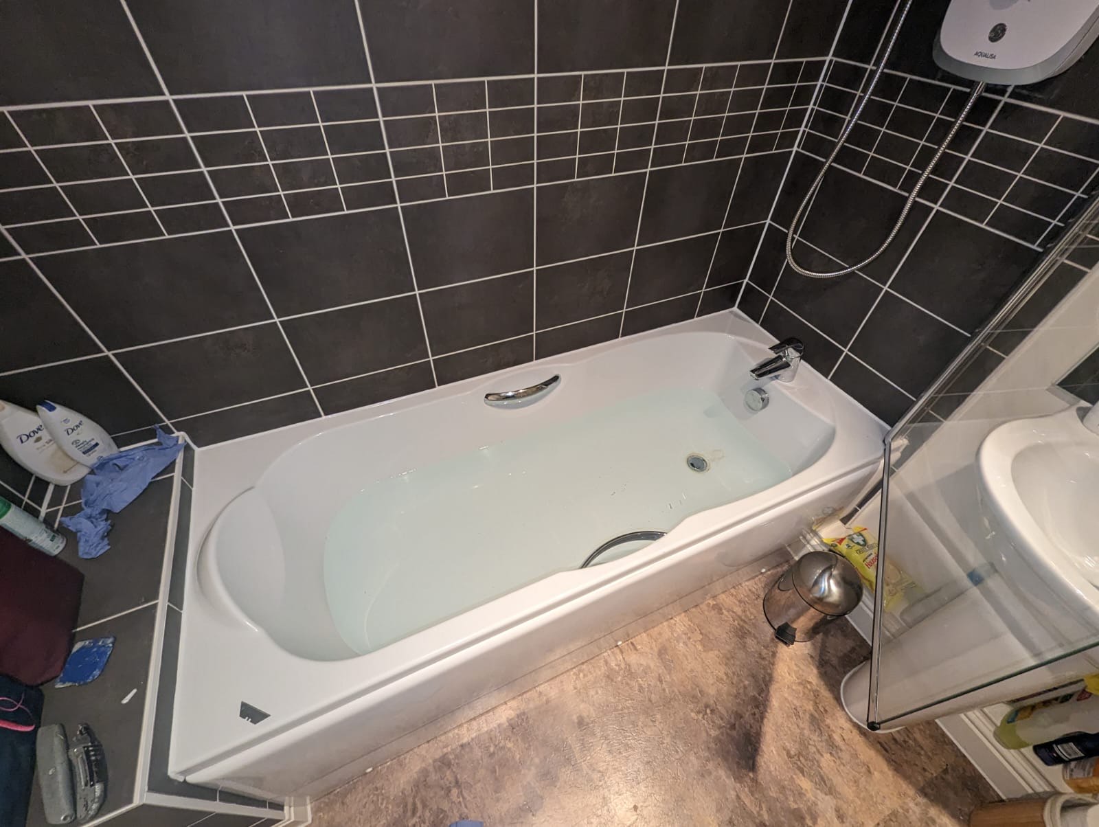 Bath installation with dark tiled surround