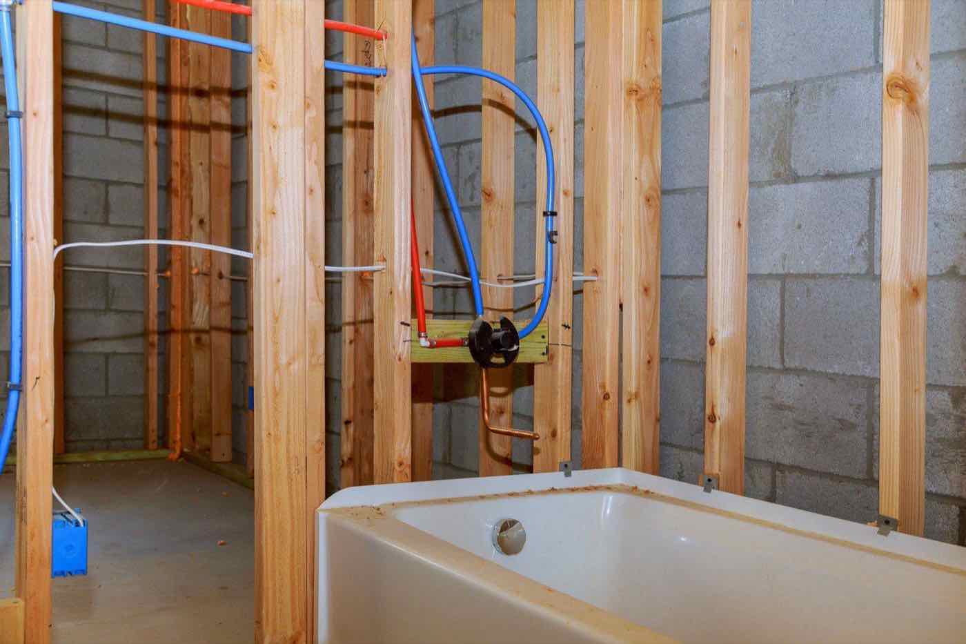 Bathroom installation in progress with new bath and copper pipework
