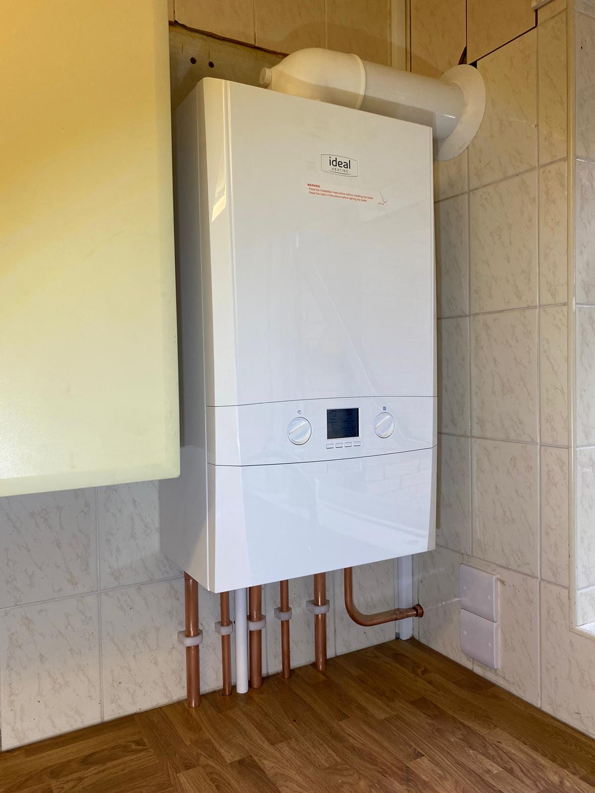 New gas boiler being installed by Plumbing Angels, with fresh copper pipework run to the wall