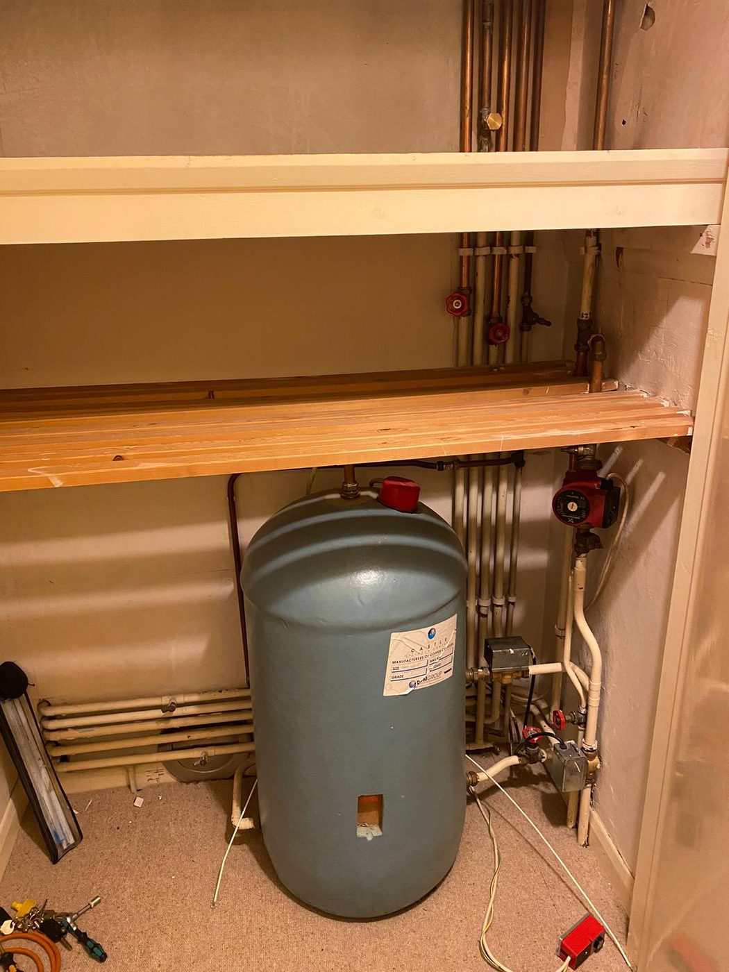Unvented hot water cylinder and pipework in an airing cupboard