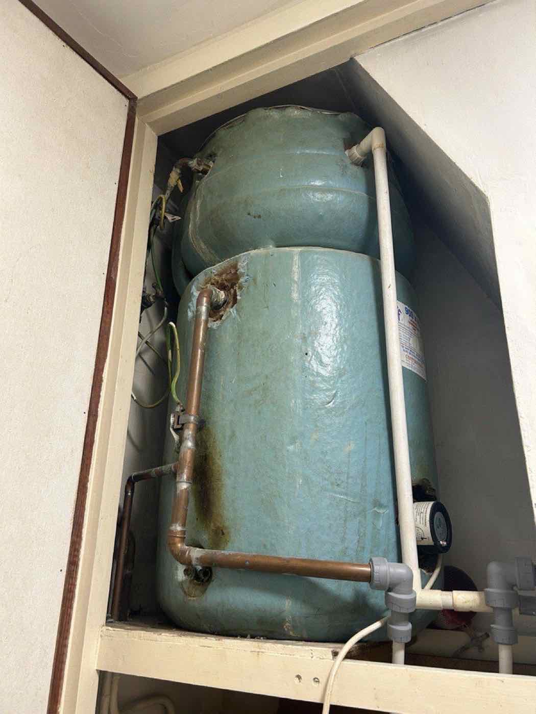 Old hot water cylinder being replaced during an upgrade