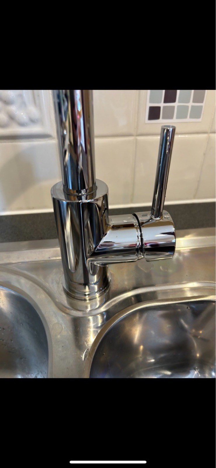 Chrome kitchen mixer tap fitted to a stainless steel sink