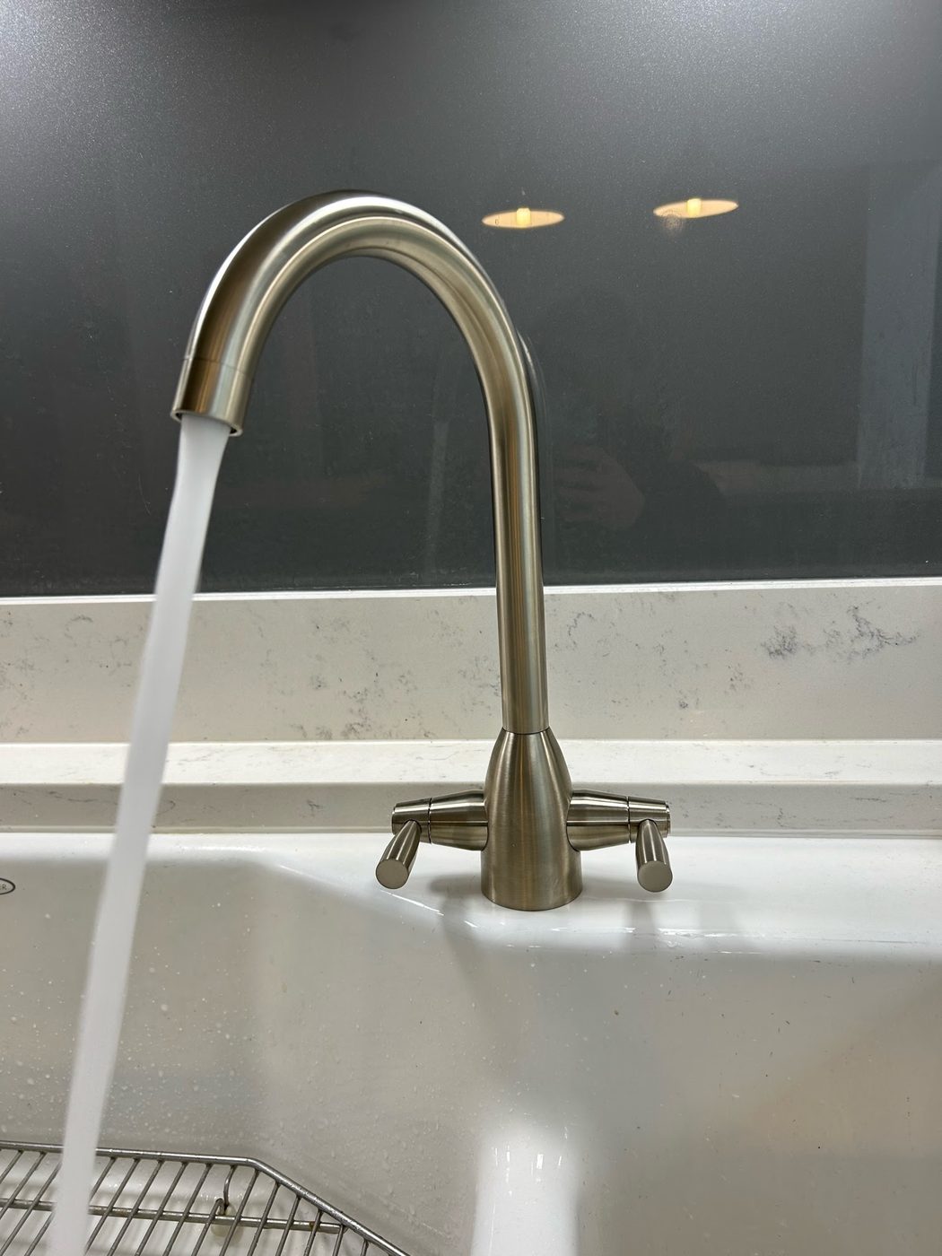 Brushed steel kitchen tap running after installation
