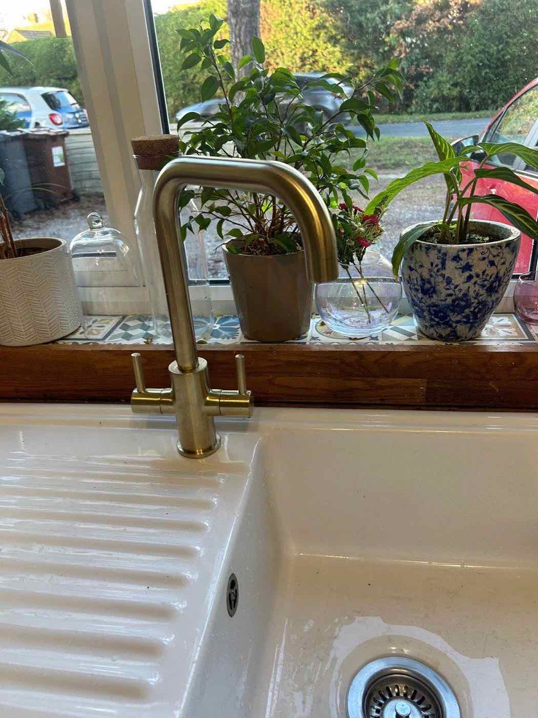 Brushed gold kitchen tap installed above a ceramic sink