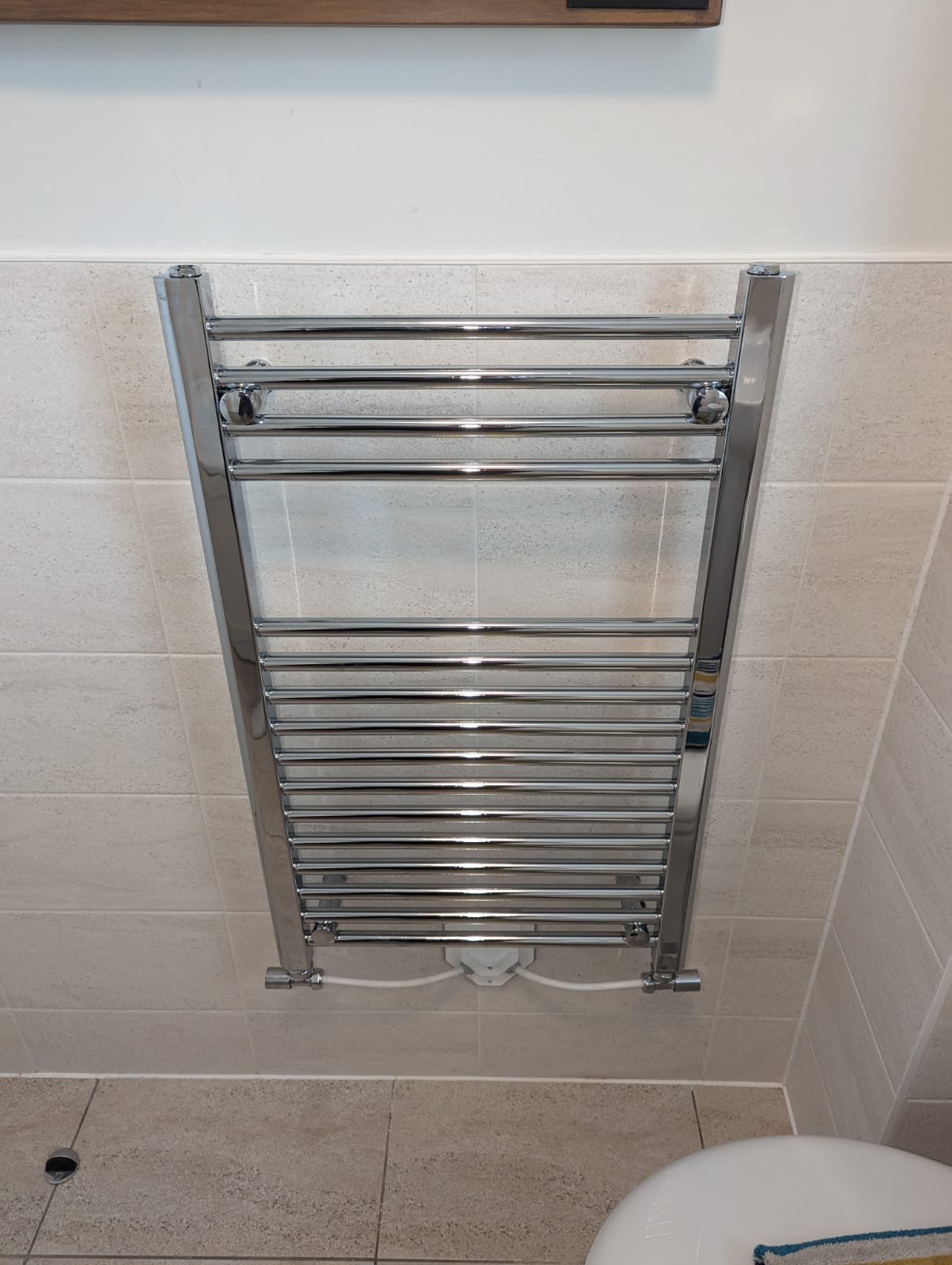 Chrome heated towel rail installed by Plumbing Angels